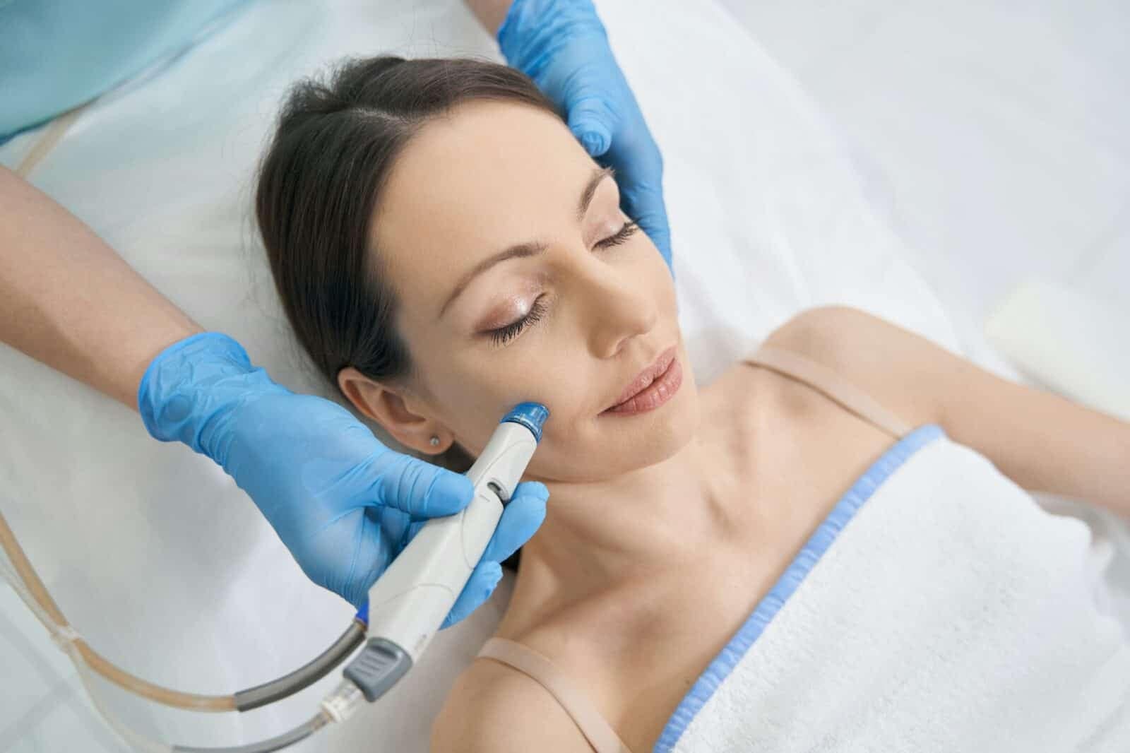 About Us Woman receiving hydrafacial treatment in beauty salon